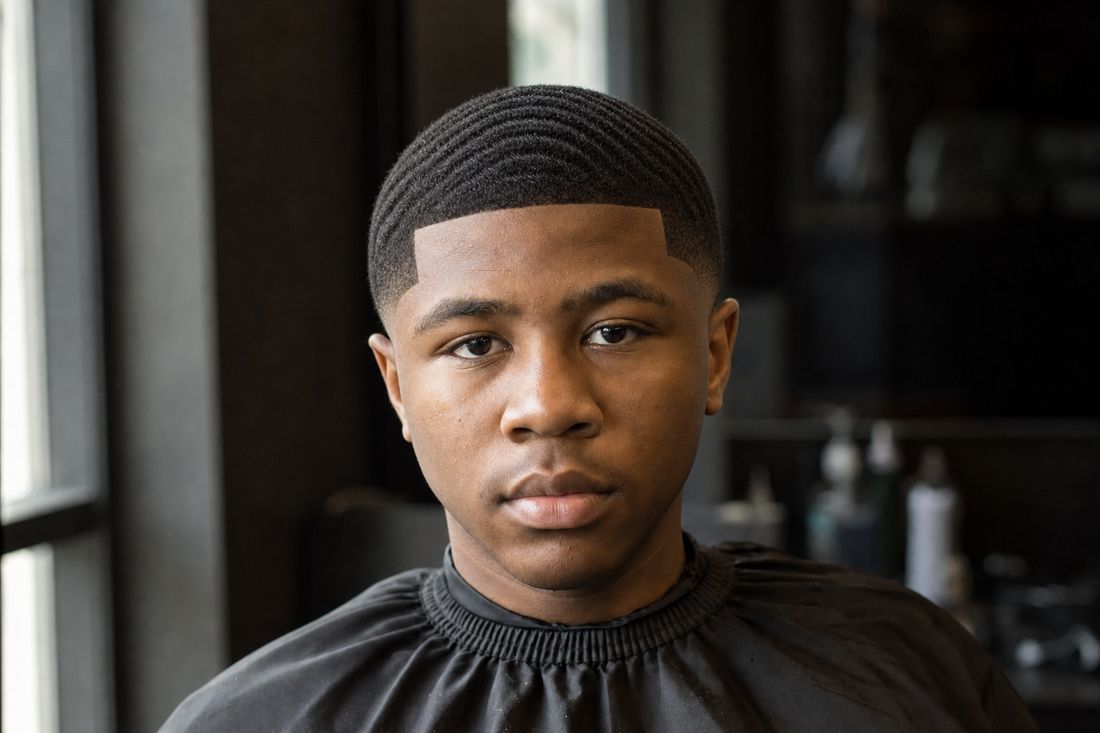 The same young client after a low taper fade with 360 waves and a sharp lineup